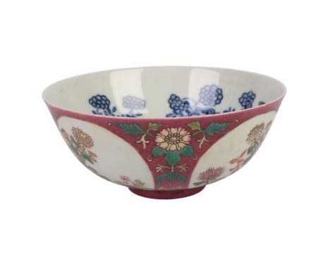 A Chinese famille rose footed bowl decorated with flowers within roundels, on a sgraffito aubergine ground and blue & white i