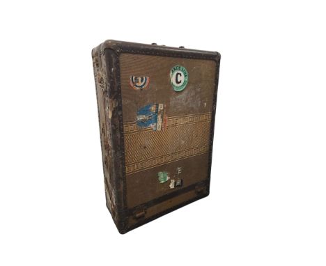 A vintage travel trunk with fitted clothes hanger interior, having various luggage labels, 73cms high. *This lot is subject t