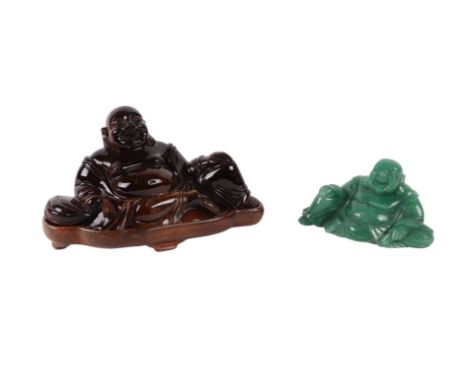 A Chinese tigers eye figure of Buddha, 15cms wide,  on a hardwood stand; together with a carved jade type figure of Buddha, 1