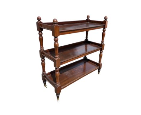 A Victorian mahogany three-tier buffet on turned supports terminating in ceramic brass casters, 104cms wide.
