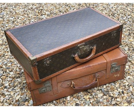 A vintage Louis Vuitton canvas hard-sided suitcase with LV monogram design, reinforced leather strapwork and brass fittings, 
