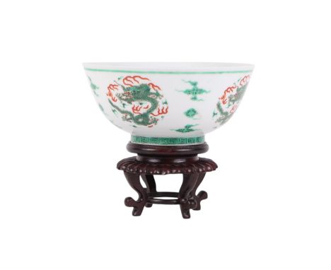 A Chinese famille vert footed bowl decorated with dragons chasing a flaming pearl amongst clouds, blue seal mark to the under