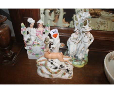 A Victorian Staffordshire spill holder in the form of deer being chased by a hunting dog; and two other Staffordshire groups 