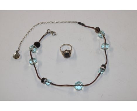 A Sterling silver and smoky topaz ring, size N/O; and a Sterling silver tipped thong necklace with polished facet cup smoky t