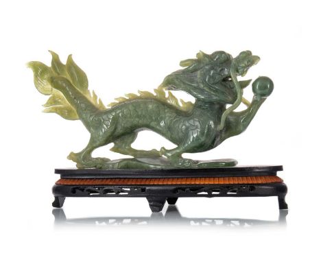 CHINESE JADE CARVING OF A DRAGON, 20TH CENTURY  posed holding the flaming pearl, on hardwood stand38cm long