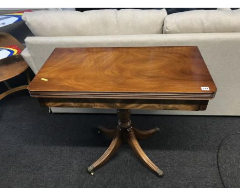 A reproduction mahogany fold over card table