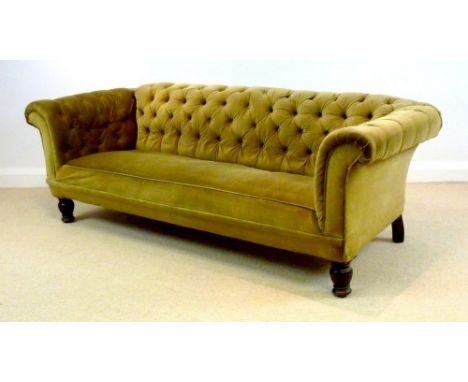 A Victorian mahogany three seater Chesterfield settee, with scroll over arms and turned front legs, upholstered in dark gold 