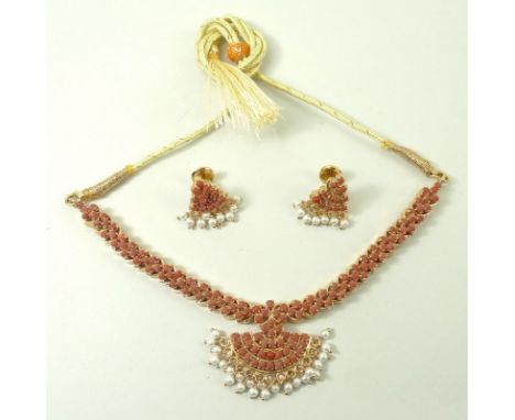 An Indian coral necklace, the coral set in gold plated on silver, with a cord tie fastener, and a pair matching earrings with