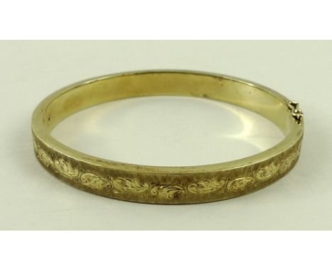A 14ct gold bangle, with engraved and textured decoration, 15.8g.