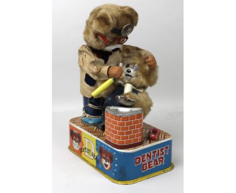 An S & E Toys (Japan) vintage 'Dentist Bear', tinplate mechanical toy, the plush covered bear operating on a smaller bear, wi