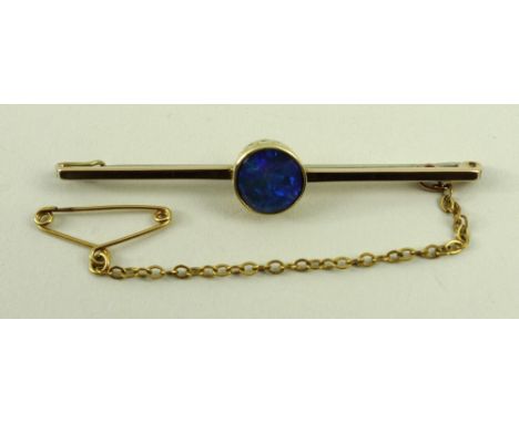 A 15ct gold and black opal bar brooch, the central circular black opal in a beaded setting, 3.2g total weight. 
