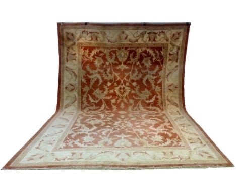 A large Iranian hand knotted carpet, red, cream and camel colours with central meanders, 425 by 311cm.