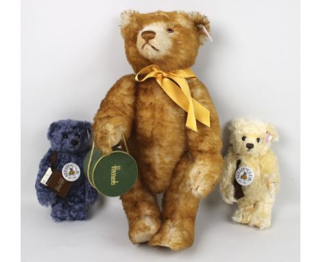 The Extravagance Bear, a Steiff Harrods musical bear, with a yellow ribbon tied around its neck and holding a Harrods hatbox 