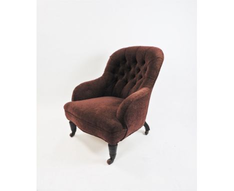 A Victorian button back tub chair, later upholstered in claret covers on ring turned tapering legs and ceramic castors