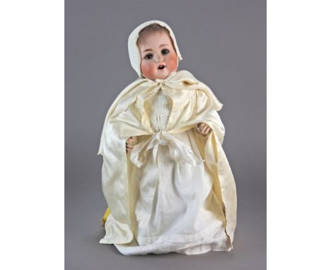 A Schutzmeister &amp; Quendt baby doll, circa 1910, wearing light brown wig, with sleeping brown glass eyes, lashes, feathere