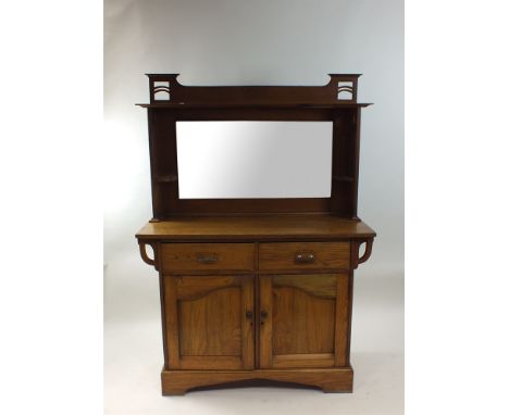 An Arts and Crafts oak mirrorback sideboard, with rectangular plate above two short drawers and two indented panel cupboard d