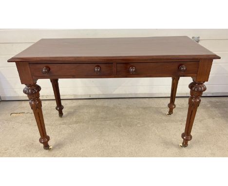 A Victorian dark wood 2 drawer hall/console table with decorative carved legs and raised on ceramic caster feet. Wooden knob 