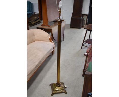 A vintage brass roman column style standard lamp with lion foot base