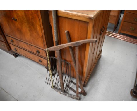 A selection of farm tools including hay fork and harp saw