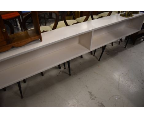 A vintage low bookshelf on dansette style legs. dimensions approx. W240cm H62cm, D22cm