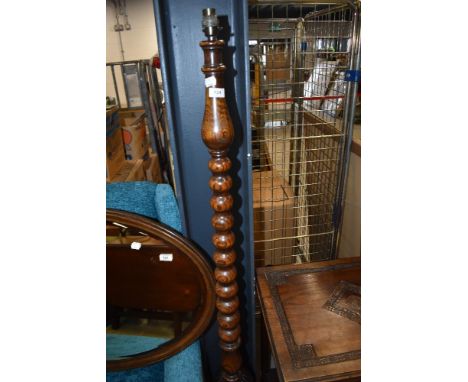 An early 20th Century oak standard lamp having cup and cover style base and turned column