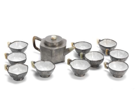 A pewter-encased Yixing teapot and a set of ten cups19th centuryThe hexagonal teapot incised with blossoming prunus and inscr