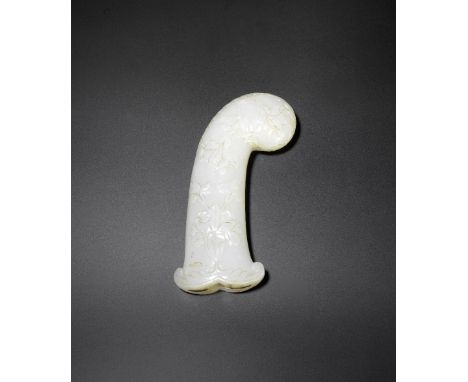 A Mughal jade sword hilt18th centuryOf pistol grip form with curved rounded pommel, carved in relief with delicate flowering 