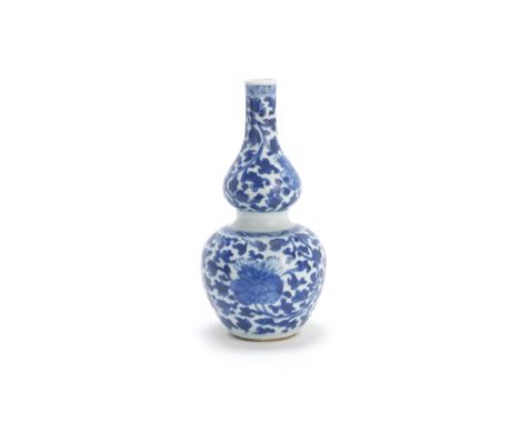 A blue and white double-gourd vaseKangxi Decorated with peony sprays and scrolling foliage.21cm (8.1/4in) highThis lot is sub