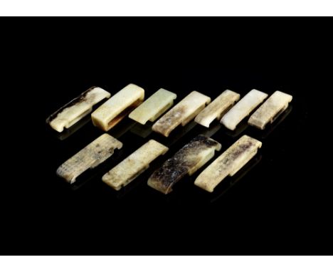 A group of eleven jade sword slidesMing DynastyVariously carved from pale green, creamy, black and grey jade, one slide with 