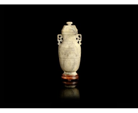 A calcified jade archaistic vase and coverMid-Qing Dynasty Of flattened baluster form, carved in low relief with a band of ta