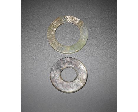 A jade disc, bi and a jade ring, huanWarring States/Han DynastyThe first, of plain circular form, carved from a mottled brown