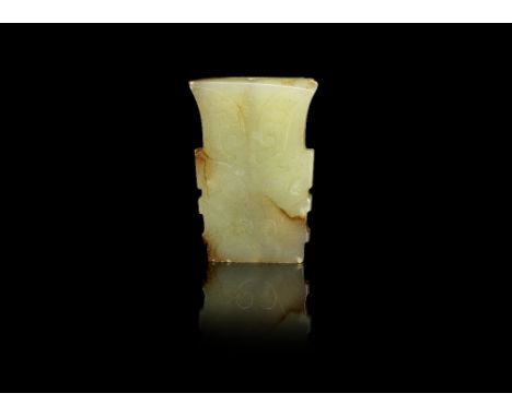 A pale green and russet jade archaistic pendantOf flaring form, carved to each side with a horned beast mask.4.8cm (1.7/8in) 