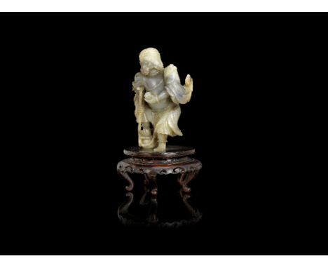 A pale green and grey jade carving of Li Tieguai18th/19th centuryThe Immortal leaning on his crutch, with his right foot rest