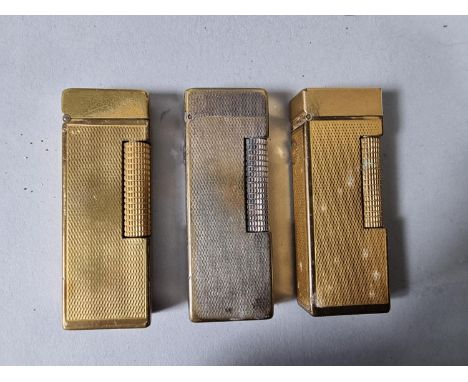 Three Dunhill lighters with engine turned decoration (3). 