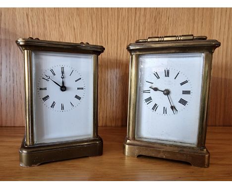A brass carriage time piece, with white enamel dial, the movement stamped Made in France 11 cm and another carriage timepiece