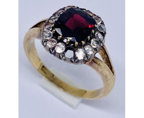 An 18ct gold cluster ring set with a garnet, two stones missing, total weight 4.9g, size P