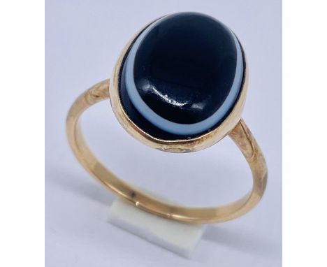 A tested 9ct gold ring set with banded agate, size P 1/2