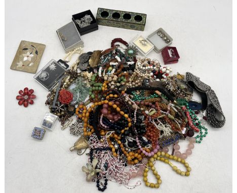 A collection of vintage costume jewellery including brooches, amber coloured beads, necklaces etc.