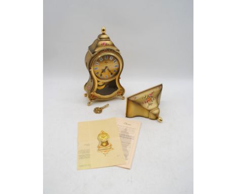 An Eluxa clock with accompanying wall bracket, key and paperwork - clock height 32cm