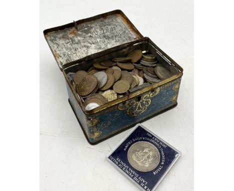 A collection of various coinage in vintage Lyon's tea money box