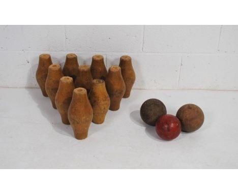 A vintage set of ten wooden skittles and three balls