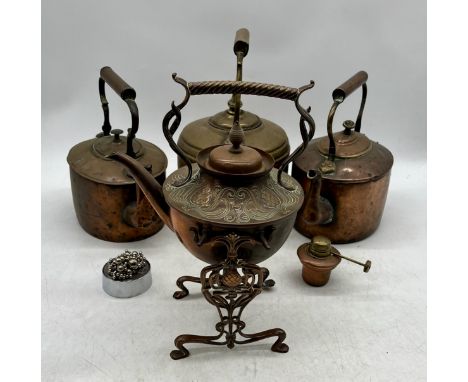 An Art Nouveau spirit kettle and stand along with three vintage copper kettles etc