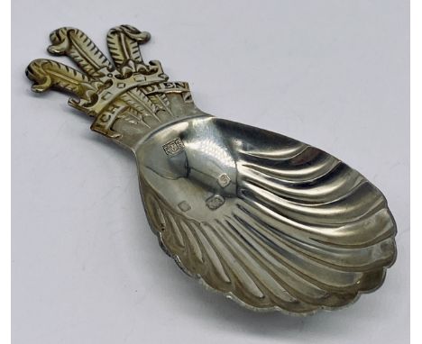 A hallmarked silver caddy spoon with fleur de lis decoration