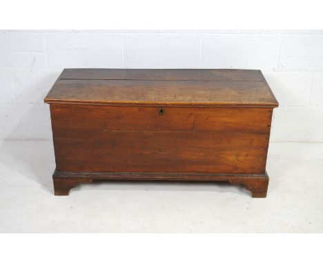An antique oak trunk, with two inner drawers, raised on bracket feet - length 110cm, depth 47.5cm, height 53.5cm