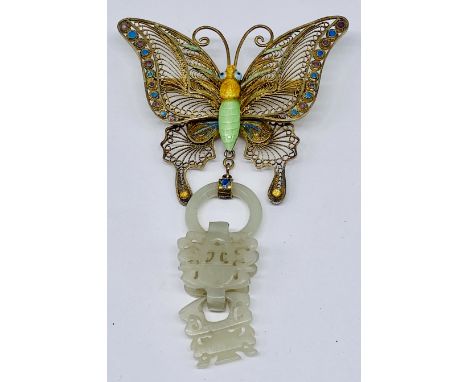 An enamelled silver gilt brooch in the form of a butterfly with jade below