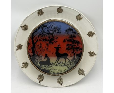 A vintage wall light with coloured silhouette landscape showing deer resting