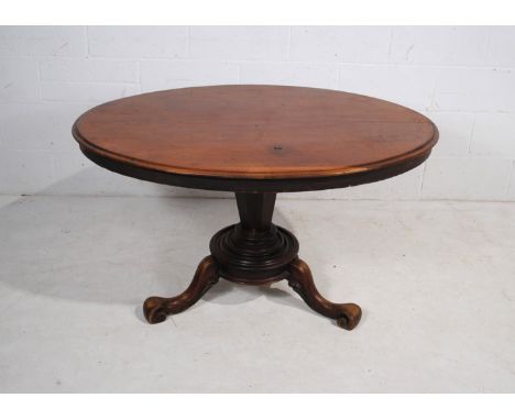 A Victorian mahogany oval tilt-top breakfast table, raised on tapering octagonal column pedestal tripod base with cabriole le