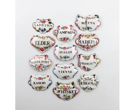 A collection of twelve enamel wine and toilet labels, cartouche and escutcheon form, with black lettering on a white ground d