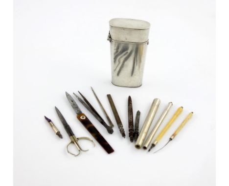 λ A white metal cased etui, unmarked, tapering oblong form, hinged cover, the interior with various medical tools, writing im