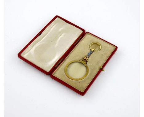 A gilt-metal and enamel spy glass, unmarked, with blue enamel decoration, in a fitted case, length 8cm.